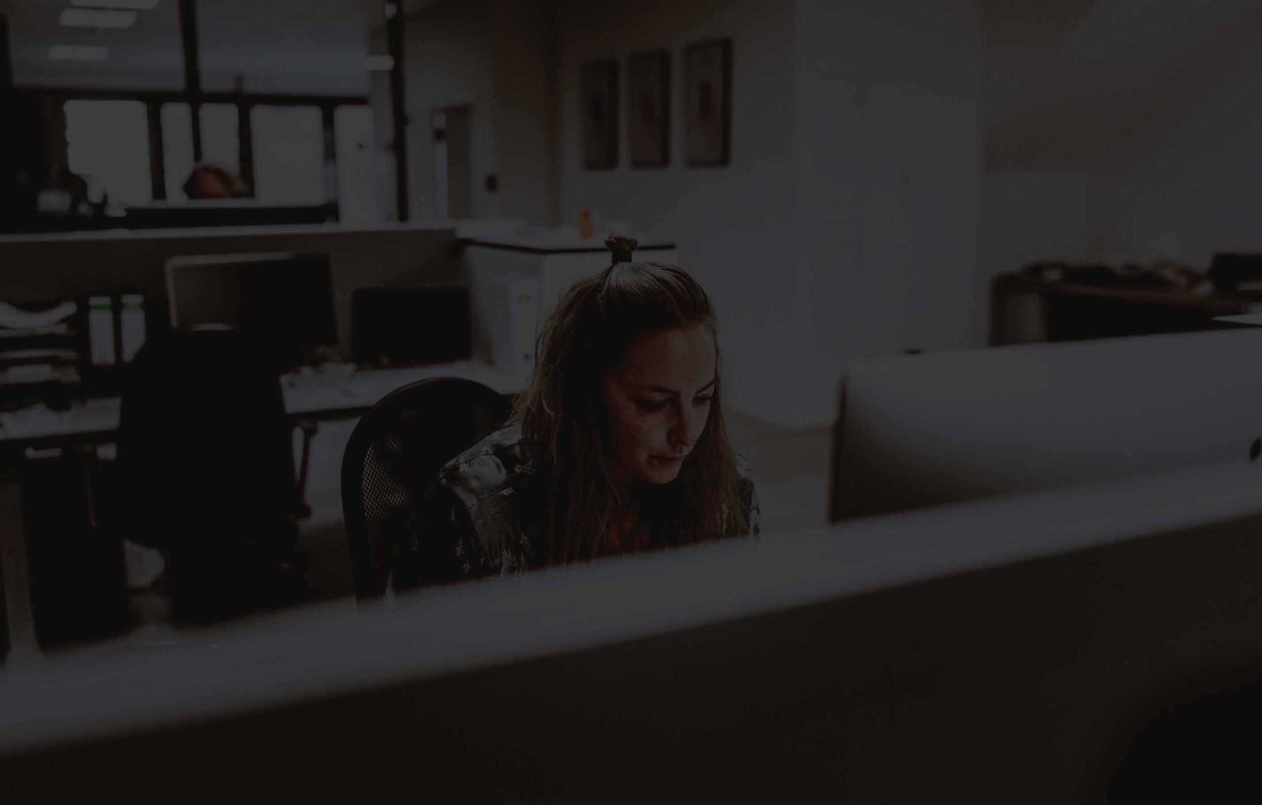 eine Person arbeitet in einem Büro an einem Computer